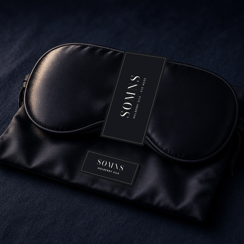 SOMNS black mulberry silk eye mask with a black SOMNS band, resting on its black silk pouch