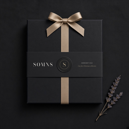 Black SOMNS gift box with a black Midnight Silk sleeve, champagne monogram seal and champagne satin ribbon