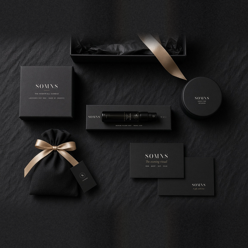 SOMNS Nightfall gift set flat-lay on black: 10 ml SOMNS Bedtime Pillow Mist in its black sleeve at the centre, with a candle in a black SOMNS carton, night-time tea tin, lavender sachet, ritual card and gift card