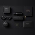 SOMNS The Night In gift set flat-lay on black: Bedtime Pillow Mist 50 ml and carton at the centre, with a glass candle in a black SOMNS box, silk eye mask, tea tin, bath flakes, evening journal and gift card