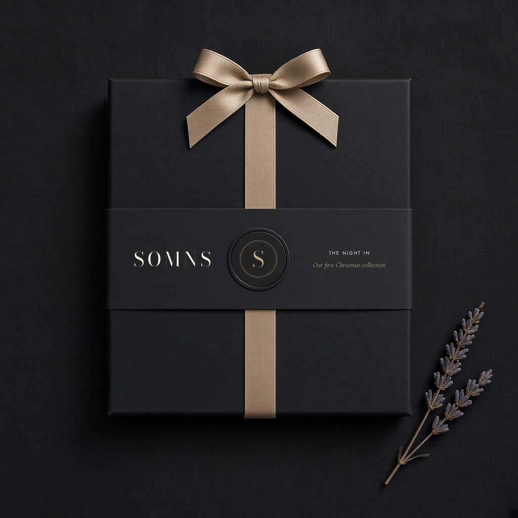 Black SOMNS gift box with a black The Night In sleeve, champagne monogram seal and champagne satin ribbon